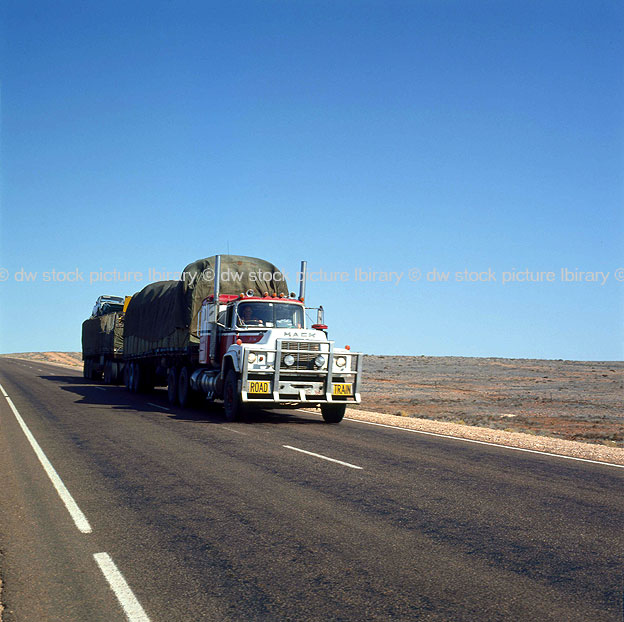 stock photo image: Transport, transportation, vehicle, vehicles, truck, Trucks, heavy vehicle, heavey vehicles, road train, road trains, roadtrain, roadtrains, outback, australian outback, outback australia, australia, nt, northern territory, outback, australian outback, outback australia, road, roads, sealed, sealed road, sealed roads, sign, signs.