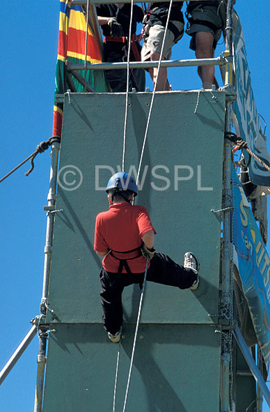 stock photo image: Australia, child, children, boy, boys, rope, ropes, abseil, abseils, abseiling, rope, ropes, helmet, helmets, hat, hats, outdoors, Sport pictures, Sports, descend, descends, descending, scaffold, scaffolds, scaffolding.