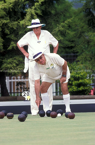 stock photo image: Sport pictures, Sports, bowls, lawn bowls, hat, hats, man, men, male, males, old man, old men, elderly man, elderly men, senior, seniors, senior citizen, senior citizens, aged people, old people, elderly people, watch, watches, wristwatch, wristwatches, wrist watch, wrist watches, people, old, aged, elderly, leisure, outdoors, ball, balls, bowling ball, bowling balls.